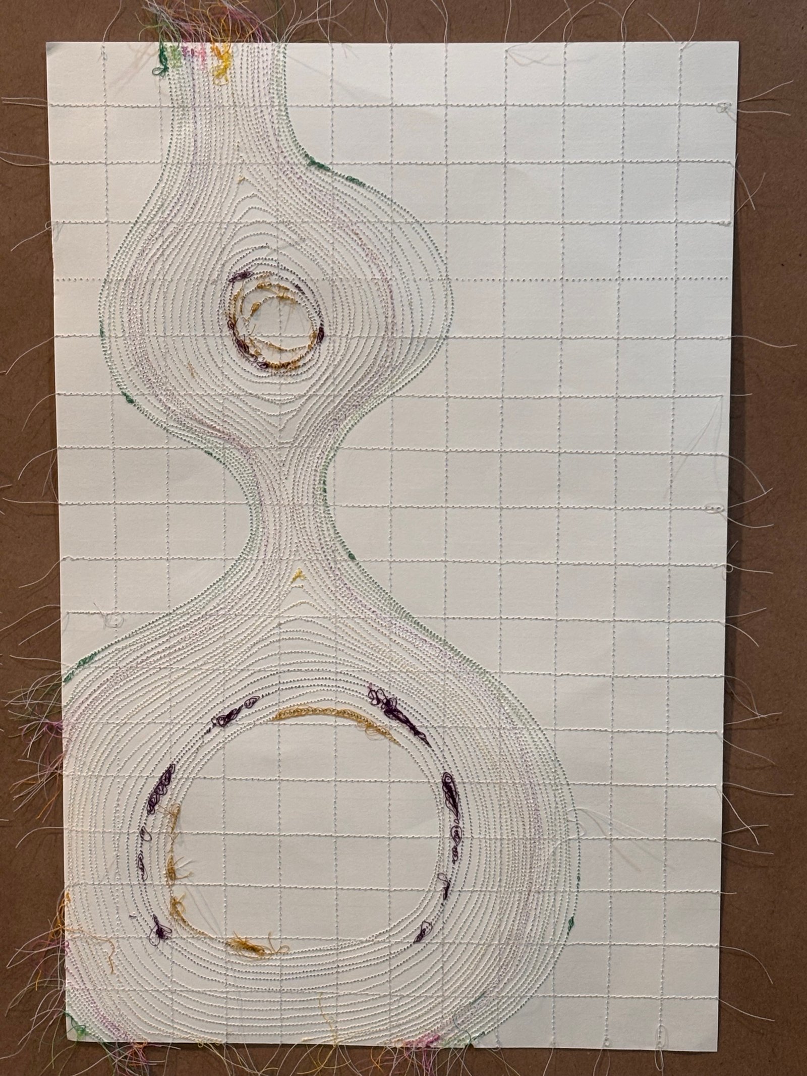 Image is a close-up of an abstract piece sewn on paper, using purple, brown, and green threads.