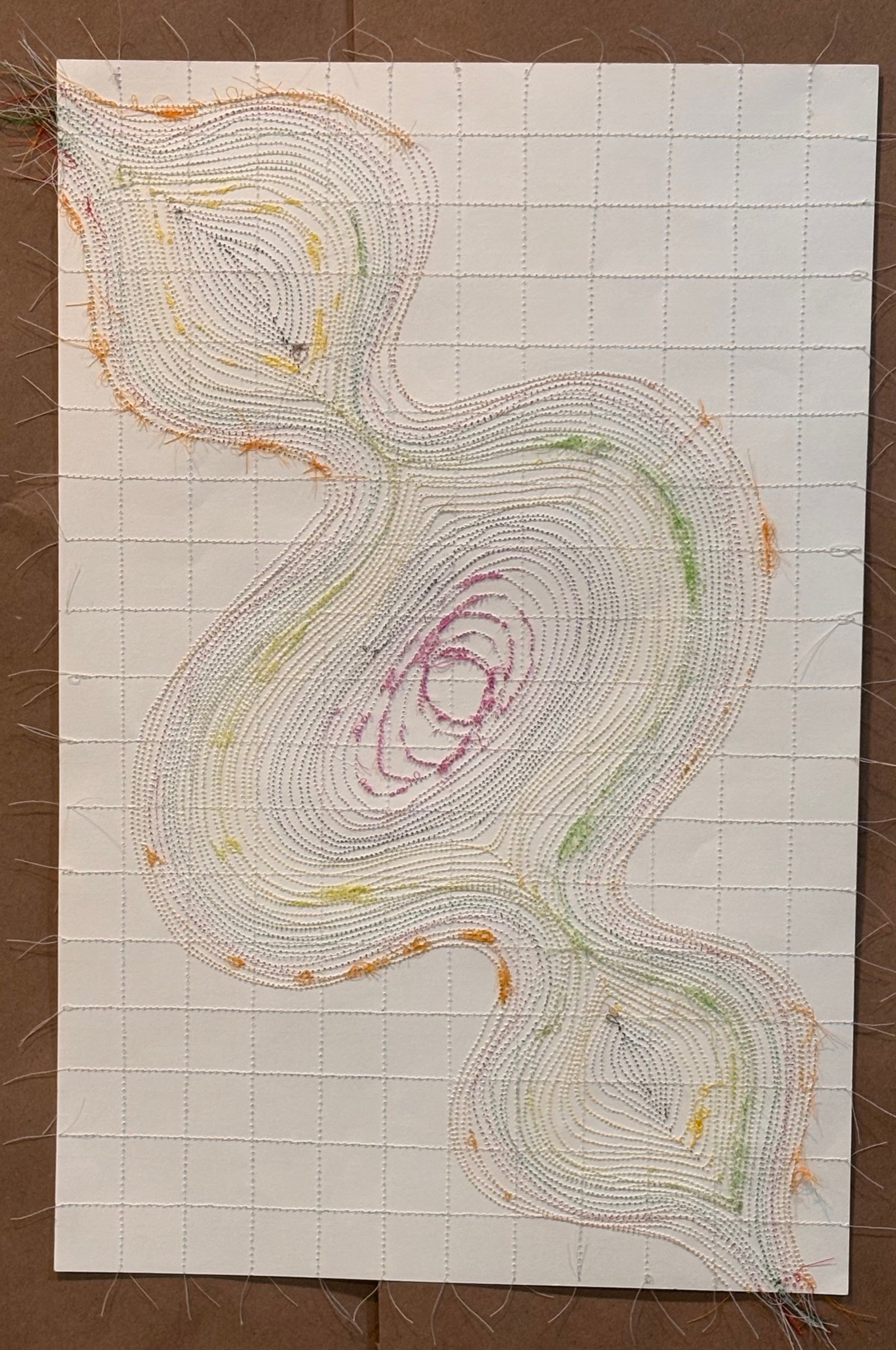 Image is a close-up of an abstract piece sewn on paper, using green, orange, yellow, and purple threads.