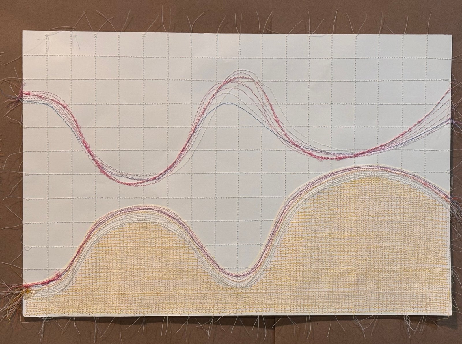 Image is a close-up of an abstract piece sewn on paper, using red, orange, yellow, pink and purple threads.
