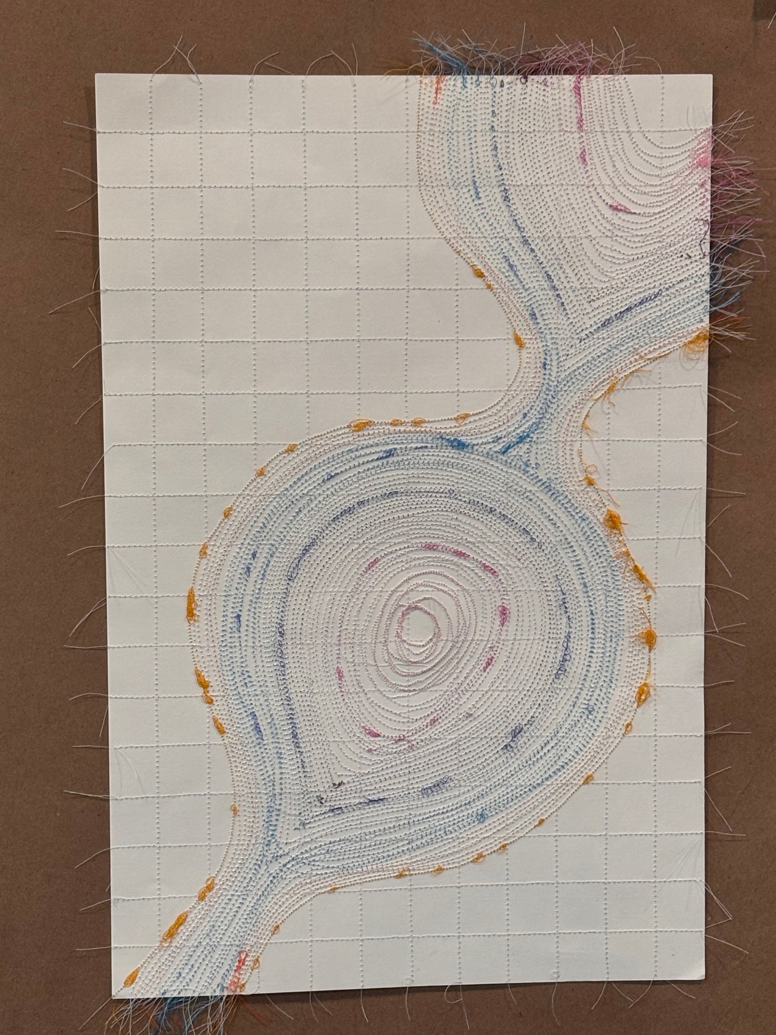 Image is a close-up of an abstract piece sewn on paper, using blue, orange, purple and hot pink threads.