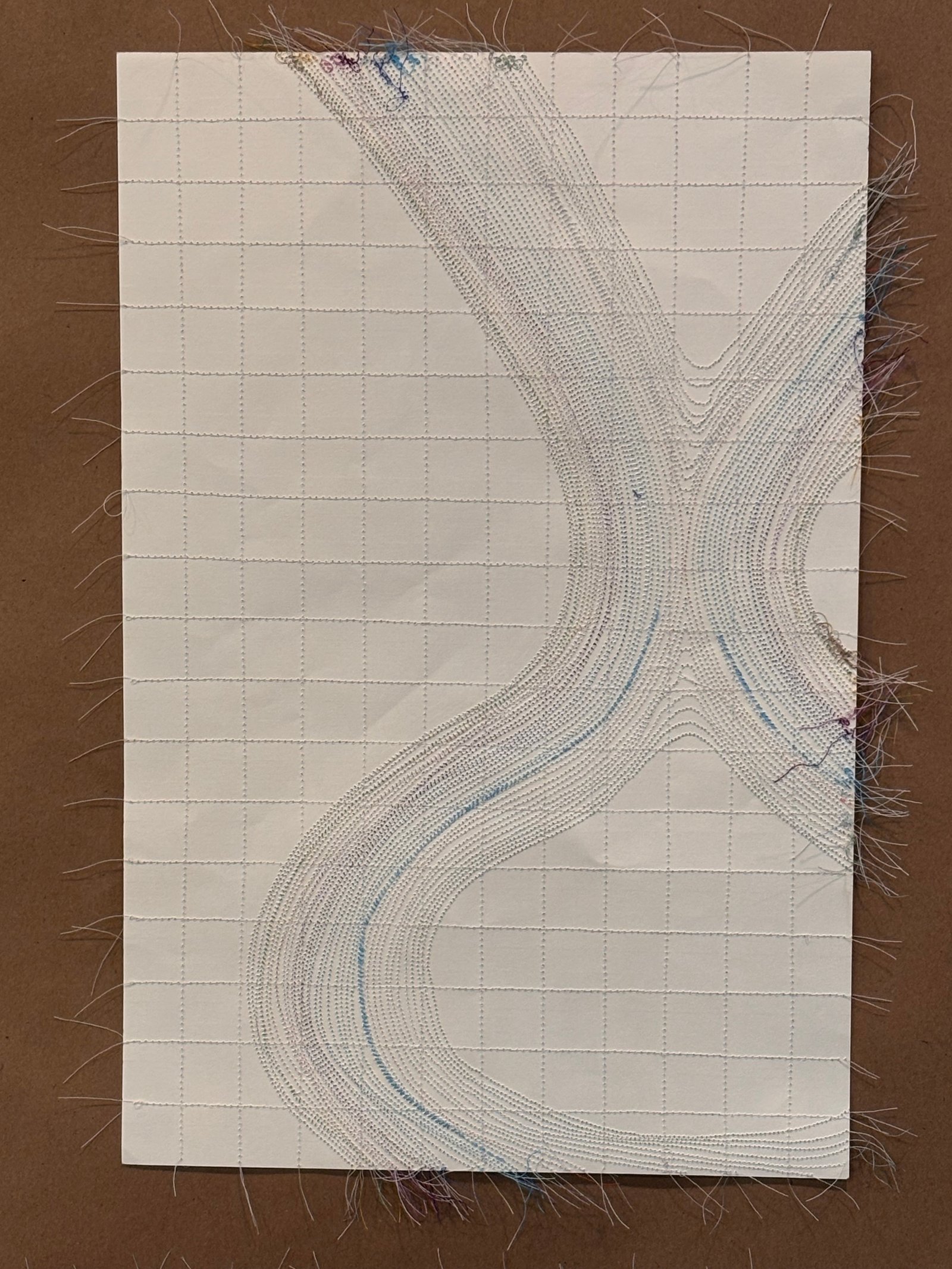 Image is a close-up of an abstract piece sewn on paper, using blue, brown, and purple threads.